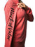 Side view of a woman wearing a pink long-sleeve shirt that has the words “Mark of Valor” printed on the right sleeve